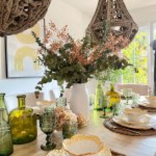Decoración de mesa de madera para celbración con detalles de flores y lámparas de ramas