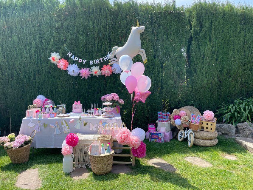 Mesa de cumpleaños decorada con flores en jardín exterior