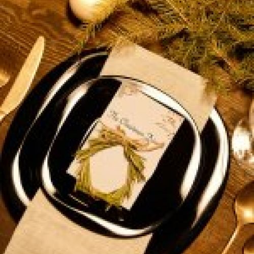Detalle de platos y cubiertos decorados en mesa  para celebración navideña