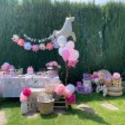 Mesa de cumpleaños decorada con flores en jardín exterior