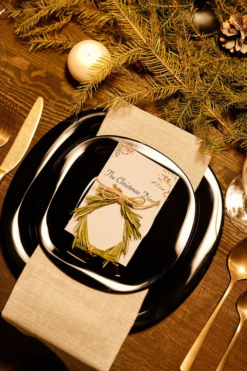 Detalle de platos y cubiertos decorados en mesa  para celebración navideña