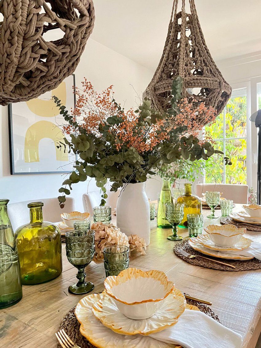 Decoración de mesa de madera para celbración con detalles de flores y lámparas de ramas